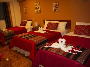 A hotel room with three beds, each with red bedding and decorative pillows. There are wall-mounted paintings and a lamp on the nightstand. - HOTEL SAN MIGUEL (Baños del Inca)