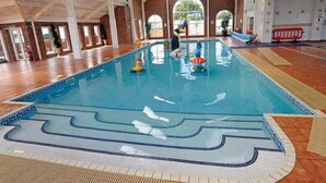 An indoor swimming pool with clear lanes, a tiled deck, and a high ceiling with skylights. - Sleeps 6, Gym, Entertainment, Pool, Beach (Rhyl)
