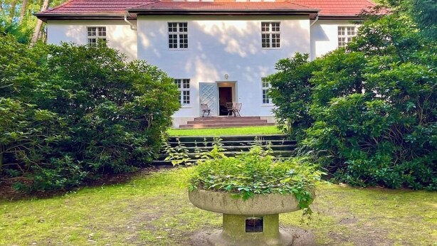 A two-story house with a red roof, white walls, and a front porch. - Park Residenz Bei Wu (Wesenberg)
