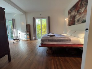 A bedroom with a bed, a chair, a window, and a painting on the wall. - Park Residenz Bei Wu (Wesenberg)
