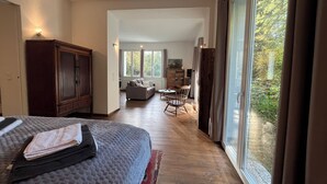 A bedroom with a bed, a wooden wardrobe, and a large window with a view of trees. - Park Residenz Bei Wu (Wesenberg)