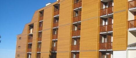 A multi-story building with a wooden facade and balconies.