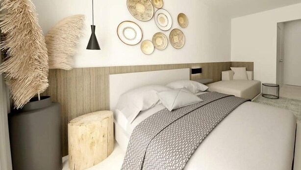 A modern bedroom with a large bed, a wooden headboard, and a wall decorated with circular plates. - Plagia Relax Hotel (Nea Propontida)