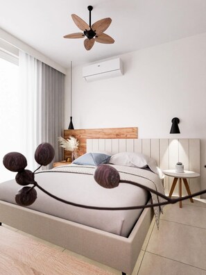 A modern bedroom with a wooden headboard, a bed with a grey and white duvet, a round table with a lamp, and a ceiling fan. - Plagia Relax Hotel (Nea Propontida)