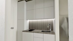 A modern kitchen with a built-in sink, a stainless steel faucet, and a sleek countertop. - Plagia Relax Hotel (Nea Propontida)