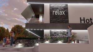 A modern hotel with a 'relax' sign, outdoor seating, and a stone facade. - Plagia Relax Hotel (Nea Propontida)
