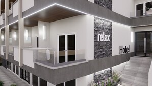A modern hotel with a minimalist design, featuring a central relaxation area with a bench and a stone accent wall. - Plagia Relax Hotel (Nea Propontida)