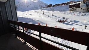 A ski resort with a chairlift, snow-covered slopes, and buildings in the background.