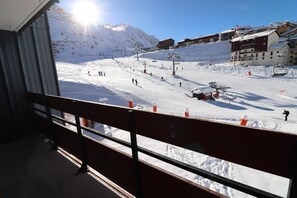 A ski resort with a chairlift, snow-covered slopes, and buildings in the background.