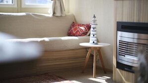 Ein gemütliches Wohnzimmer mit einer Couch, einem kleinen runden Tisch und einem dekorativen Gegenstand sowie einem modernen Kamin.