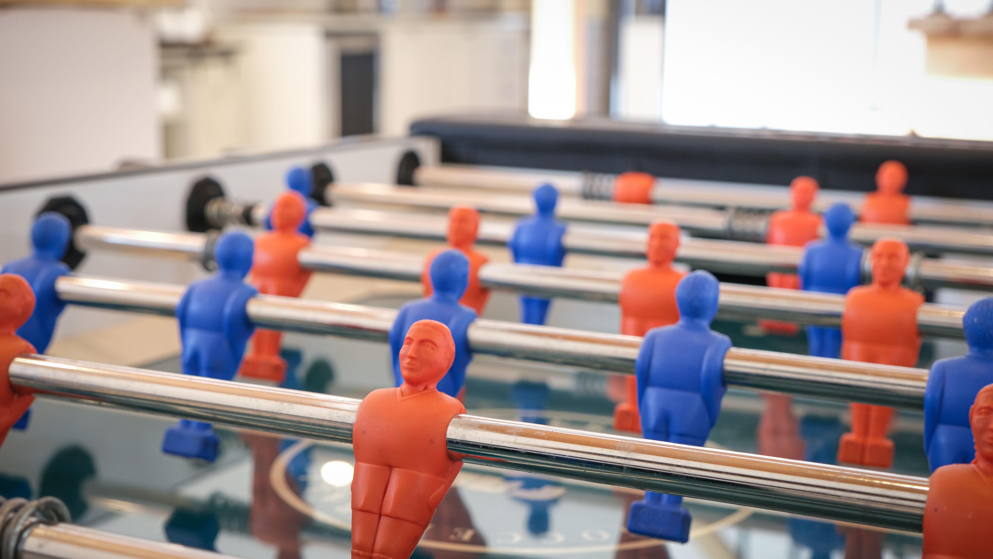 Una mesa de fútbol de mesa con figuras de jugadores rojas y azules.