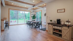 Una cocina amplia con techo de madera, ventanas grandes y una barra de café.
