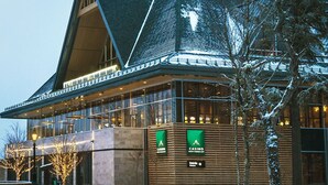 Un bâtiment moderne doté d’une grande façade en verre, d’un revêtement extérieur en bois et d’une enseigne indiquant qu’il s’agit d’un casino.