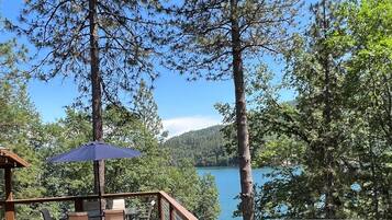 Eine Holzterrasse mit Sitzgelegenheiten und Blick auf einen See.