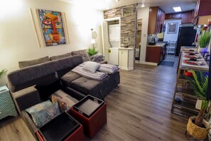Relax in this inviting living space with a comfortable sofa, coffee table, and kitchenette.