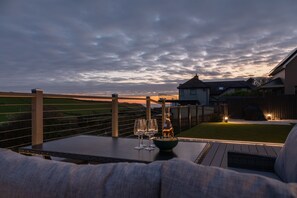 Une terrasse avec une table, trois verres à vin et un bol de collations.