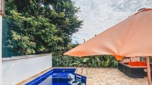 A swimming pool with a stone patio and outdoor furniture. - casaJOMO (Rio de Janeiro)