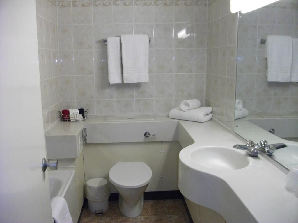 A bathroom with a bathtub, toilet, sink, and a mirror.