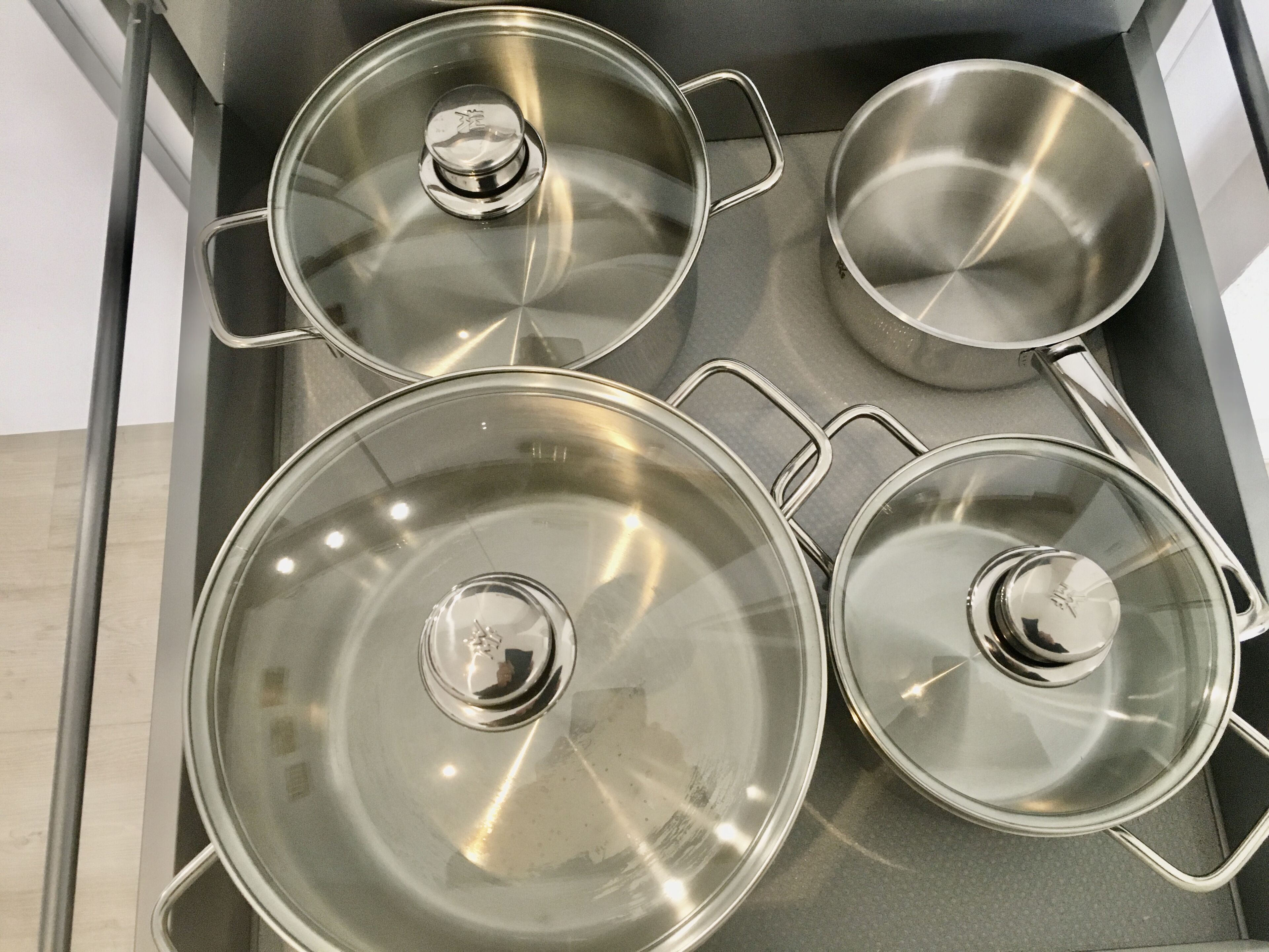 A stainless steel stove top with three pots and pans.