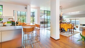 Una cocina moderna con comedor, ventanas amplias y vistas al exterior.