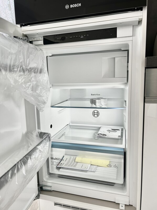 An open refrigerator with multiple shelves, including a 'MultiBox' compartment and an 'EcoAirflow' feature. - Apartment with a view of the seawall for up to 4 people - Turquoise (Büsum)