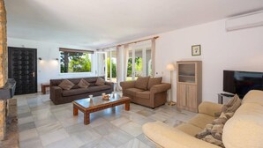 A living room with two sofas, a coffee table, a TV, and a cabinet. - Villa Mi Sueno by Villa Plus (La Capellania)