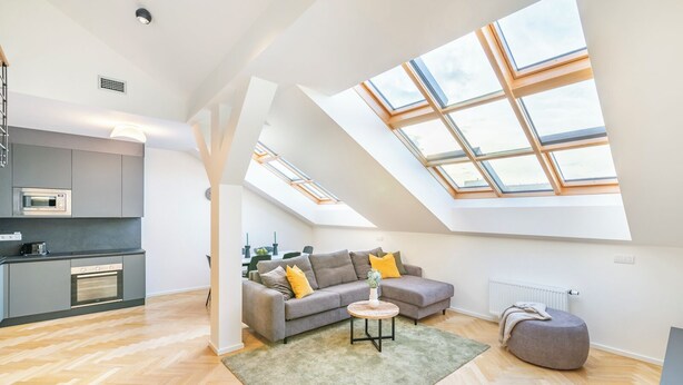 A modern loft apartment with a kitchen, living area, and skylight. - Petrin Tower Residence (Prague)