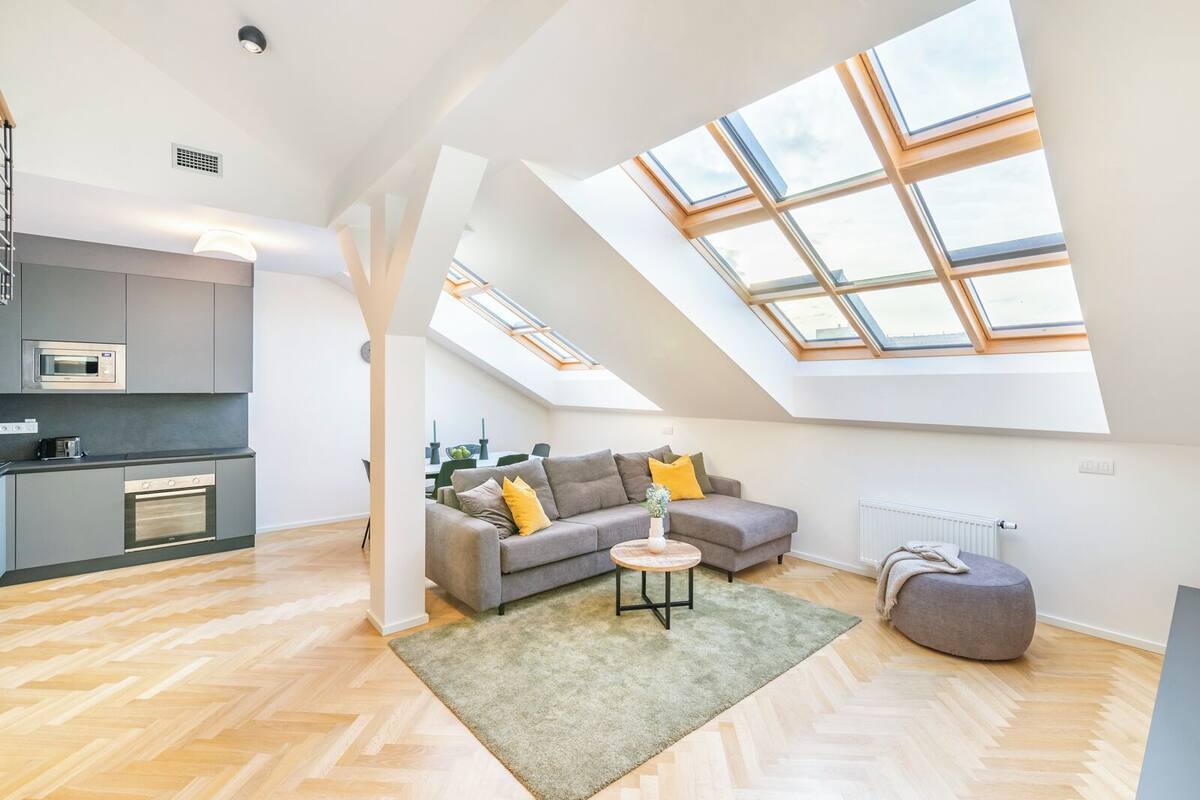 A modern loft apartment with a kitchen, living area, and skylight.
