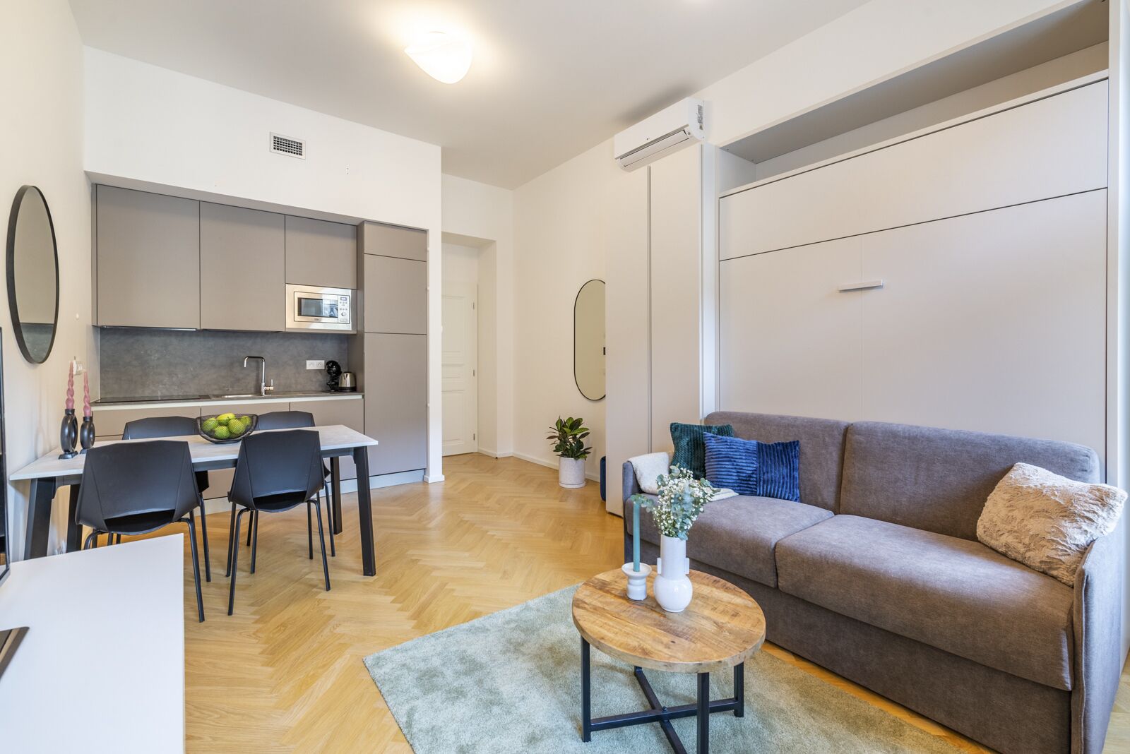 A modern apartment with a kitchen, dining area, and living room.