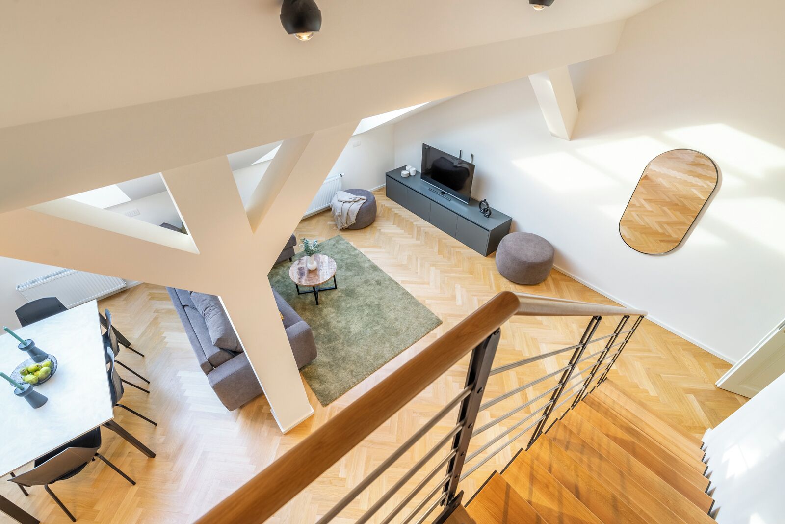 Um apartamento moderno no estilo loft, com área de refeições, sala de estar e escada.