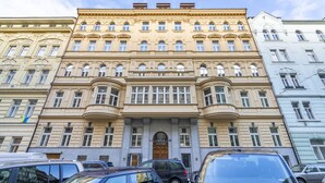 A multi-story building with classical architecture, featuring a central entrance with a wooden door and multiple windows. - Petrin Tower Residence (Prague)