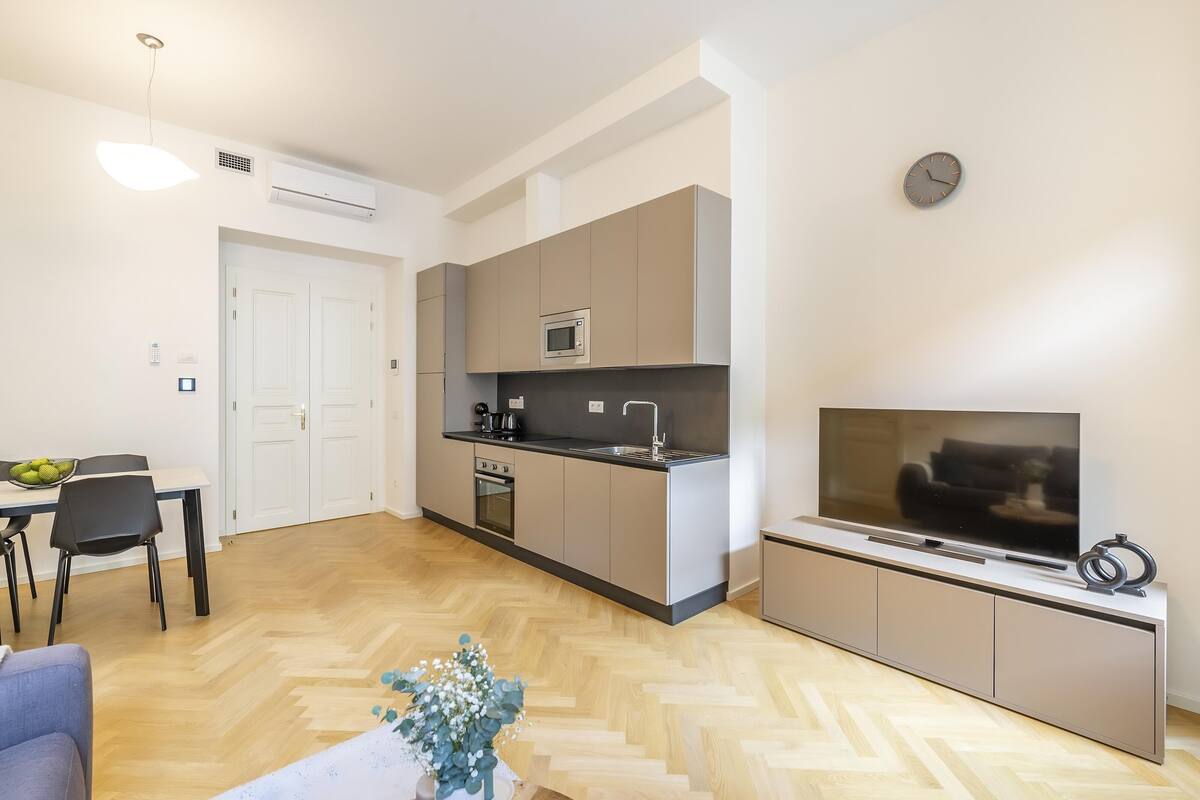 A modern apartment with a kitchen, dining area, and living room.