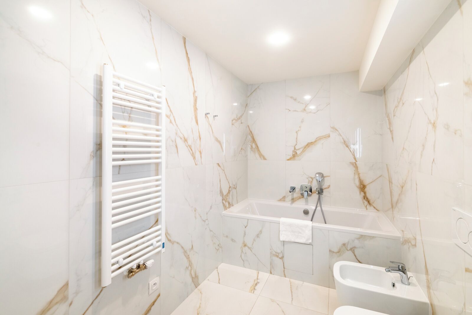 Een badkamer met een bad, een douche en een wastafel.