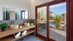 Un baño moderno con un espejo grande, dos lavamanos y un mueble de tocador de madera.