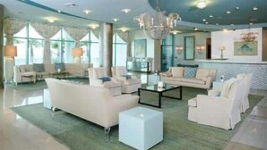 Un vestíbulo amplio con una zona de estar espaciosa, un candelabro y ventanas grandes.