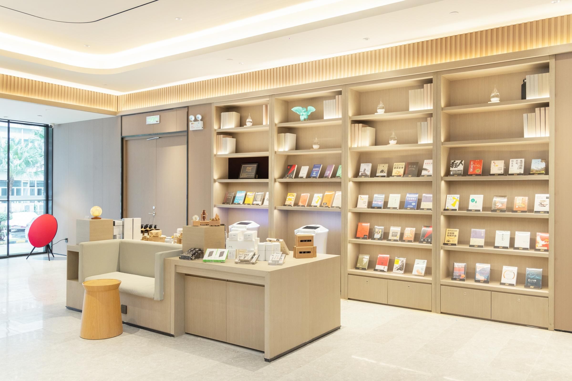 Una librería moderna y bien iluminada con una gran variedad de libros y objetos decorativos en sus estanterías.