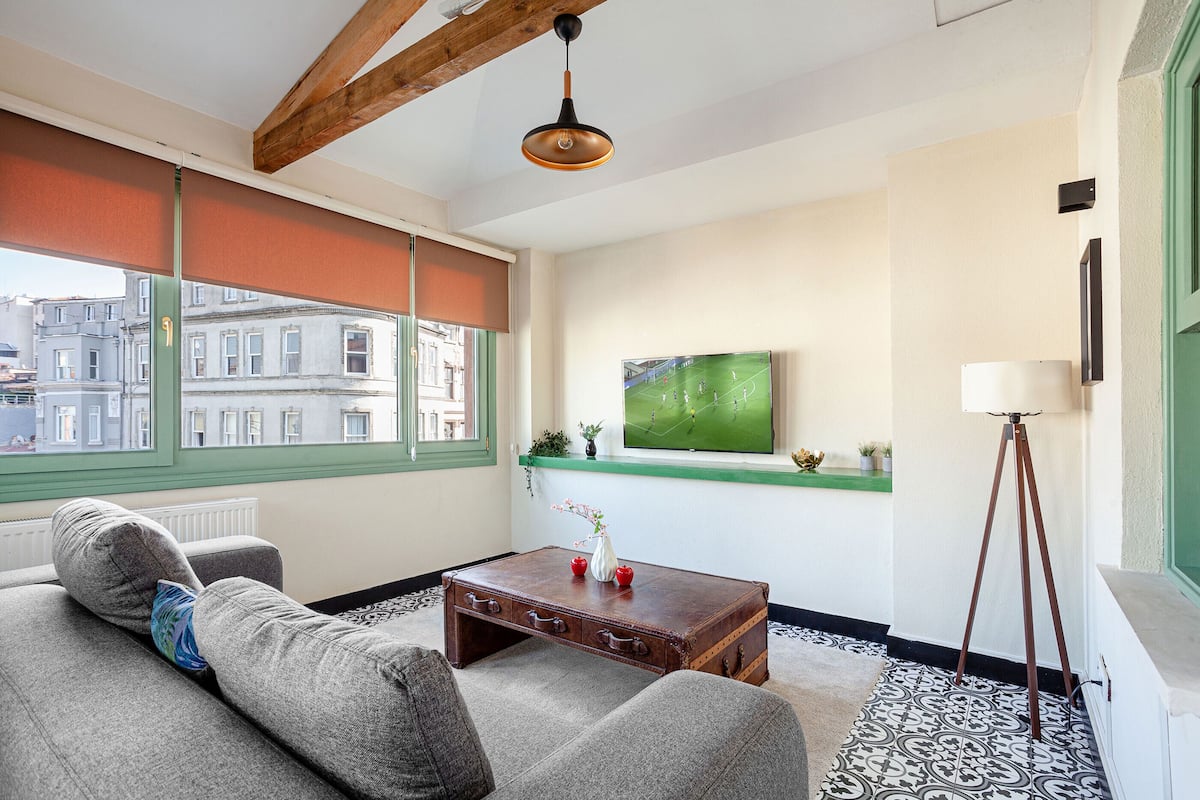 A living room with a sofa, a coffee table, a floor lamp, and a painting on the wall.