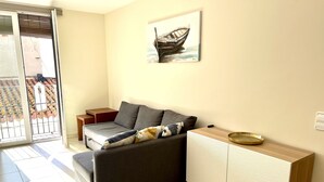 Uma sala de estar moderna com um sofá cinzento, uma mesa lateral de madeira e um armário.