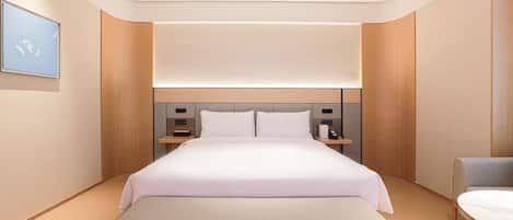 Una habitación de hotel moderna con una cama grande, mesitas de noche, un banco y vistas al cielo.