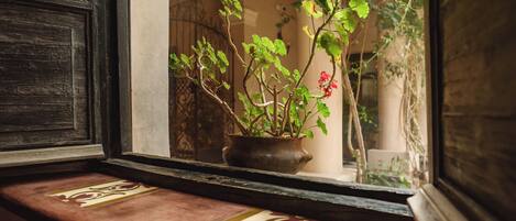 Una ventana con una maceta y un alféizar decorativo.