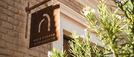 A sign for 'VIEJA POSADA HOTEL HISTORICO' mounted on a brick wall.