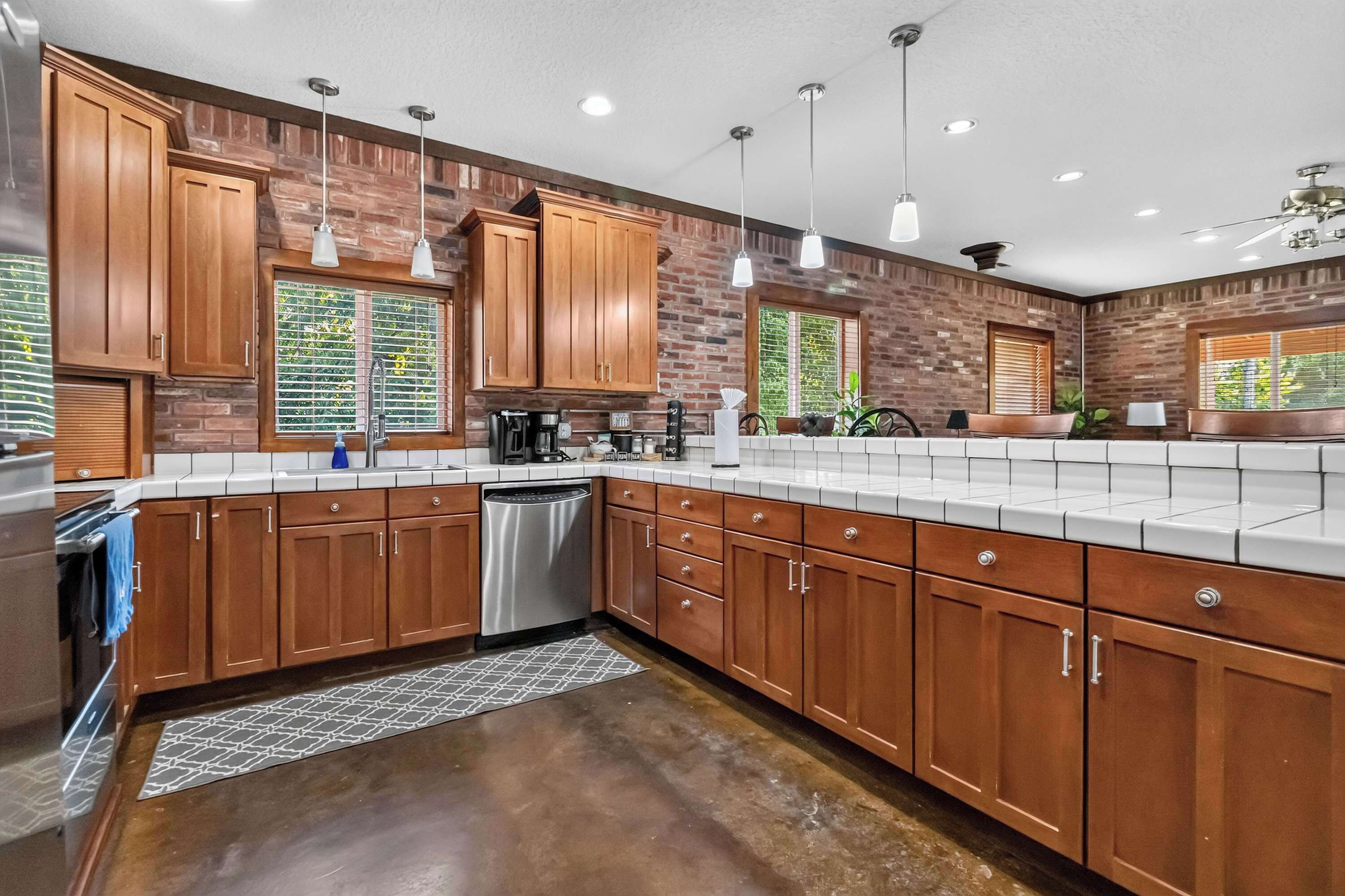 A kitchen with wooden cabinets, a dishwasher, and a countertop with various appliances.