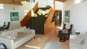 Een moderne woonkamer met een trap, een bank, een salontafel en een televisie.