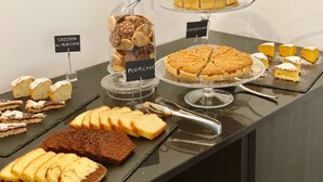 A dessert display with various cakes and pastries, including a plum cake and a chocolate cake. - Resort Hotel Tamerici (Marciana Marina)