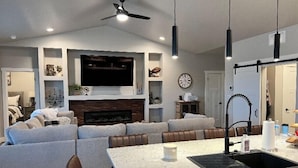 A modern kitchen with a large island, built-in seating, and a fireplace. - Spectacular Mesa view 3 room home  (Grand Junction)