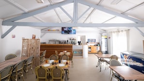 A restaurant with high ceilings, exposed beams, and a bar area.