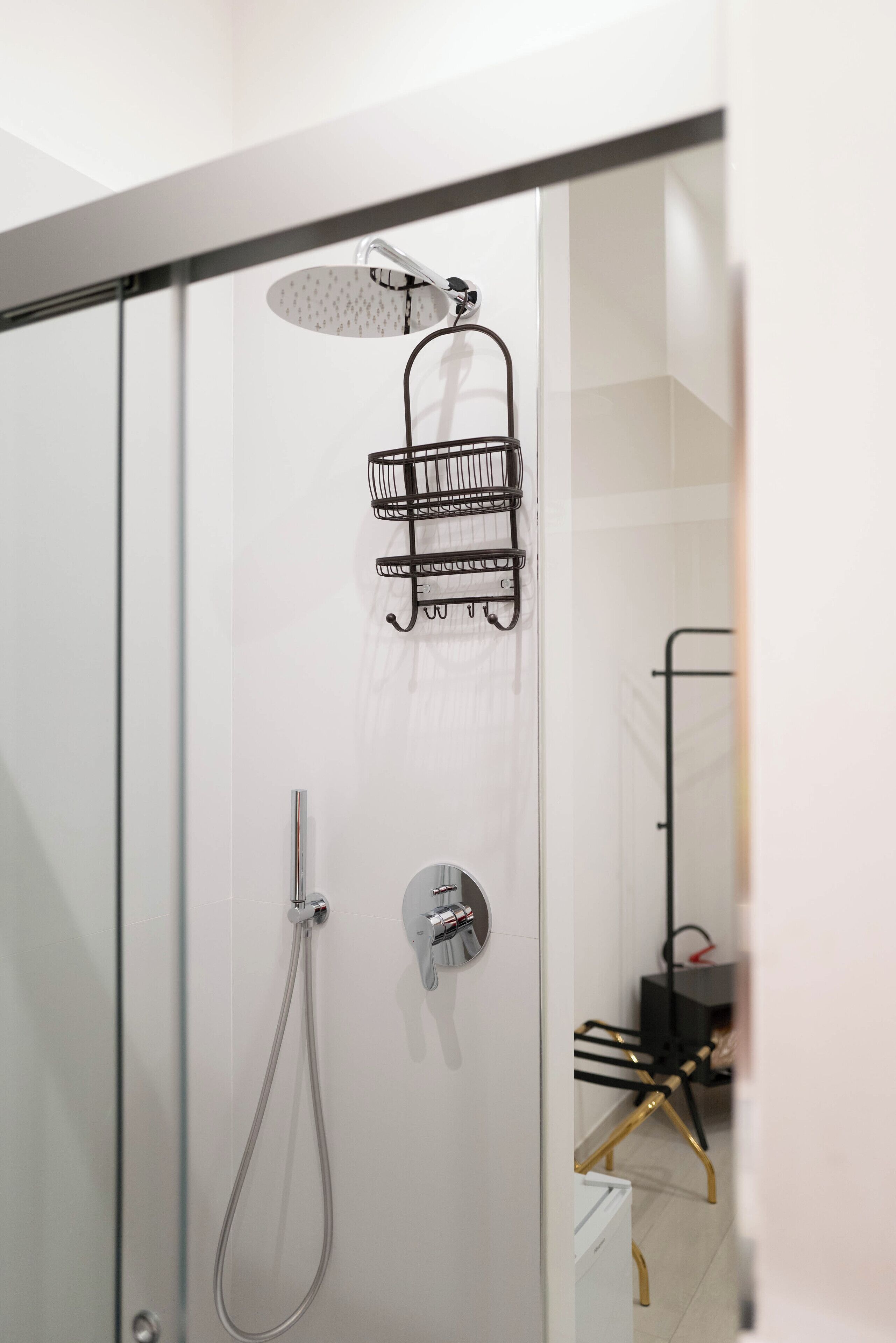 A modern shower with a handheld showerhead and a wall-mounted rain showerhead.