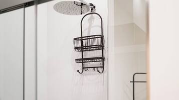 A modern shower with a handheld showerhead and a wall-mounted rain showerhead.