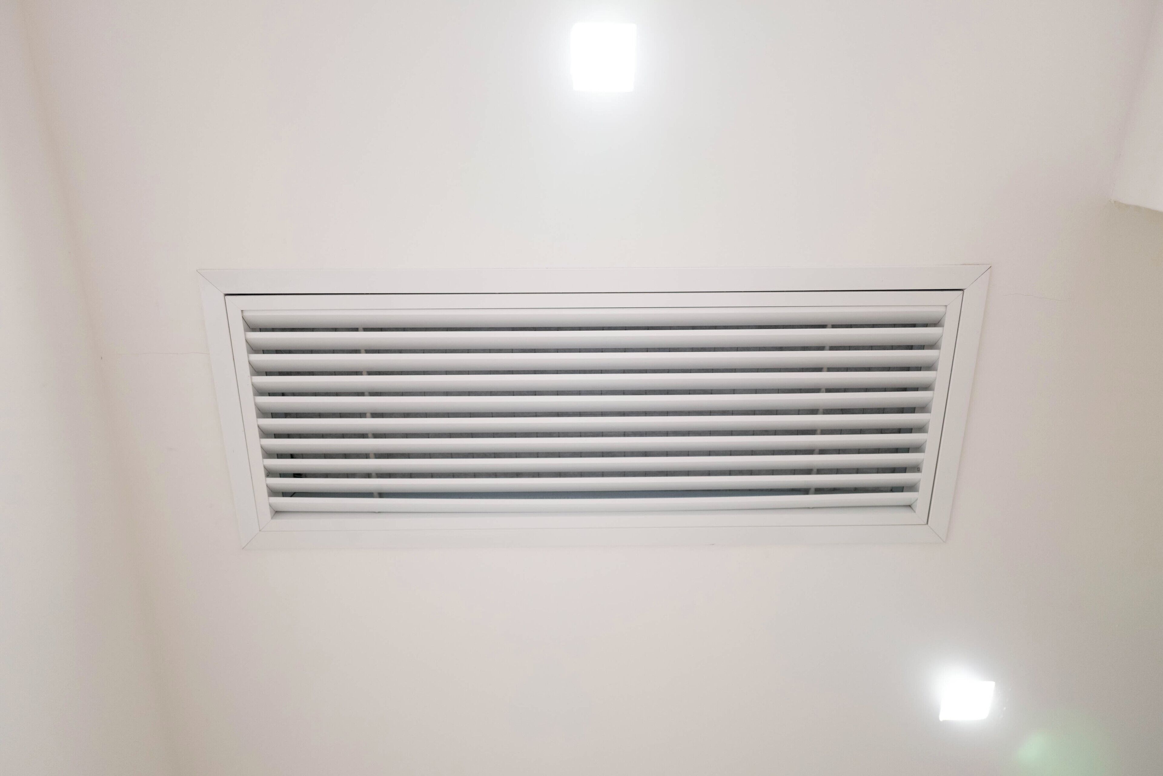 A ceiling with a rectangular vent.