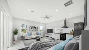 Un espace de vie moderne à aire ouverte comprenant une cuisine, un coin repas et une chambre.